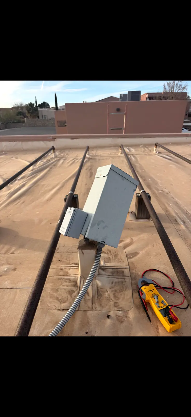 Rooftop AC disconnect with Las Cruces mesa view in the background